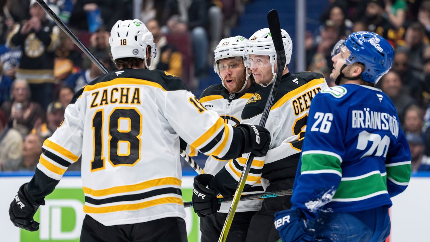 Morgan Geekie (39) celebrates his first-period goal with Pavel Zacha and David Pastrnak on Saturday night in Vancouver.