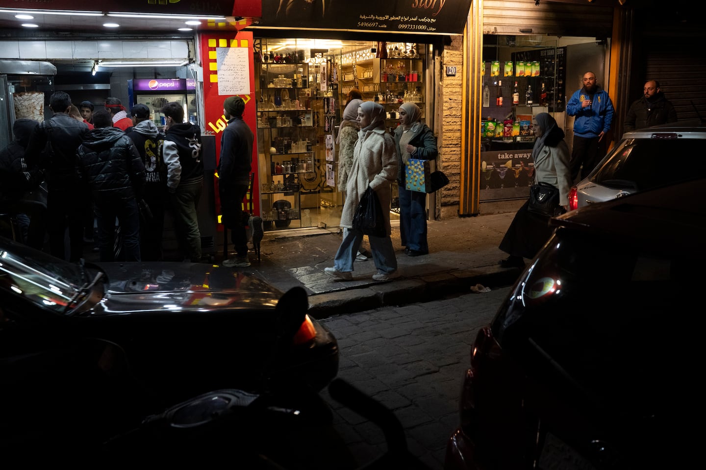 People walk past shops on a street in the Bab Touma neighborhood of the Old City of Damascus, Syria, on Dec. 14.