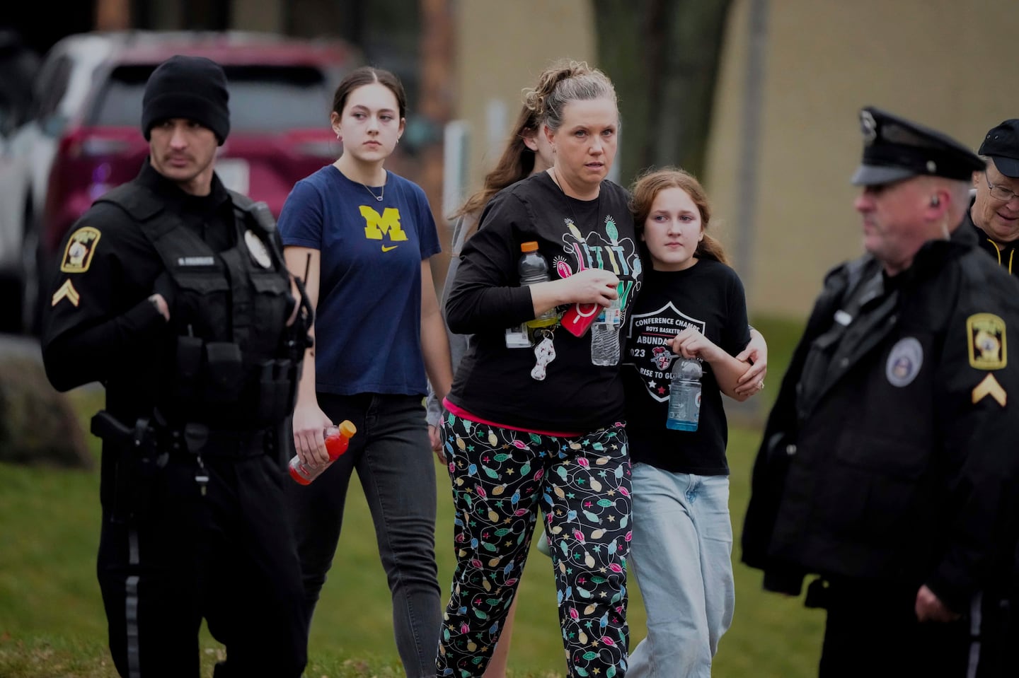 A family leave the shelter after multiple injuries were reported following a shooting at the Abundant Life Christian School, Monday, Dec. 16, 2024.