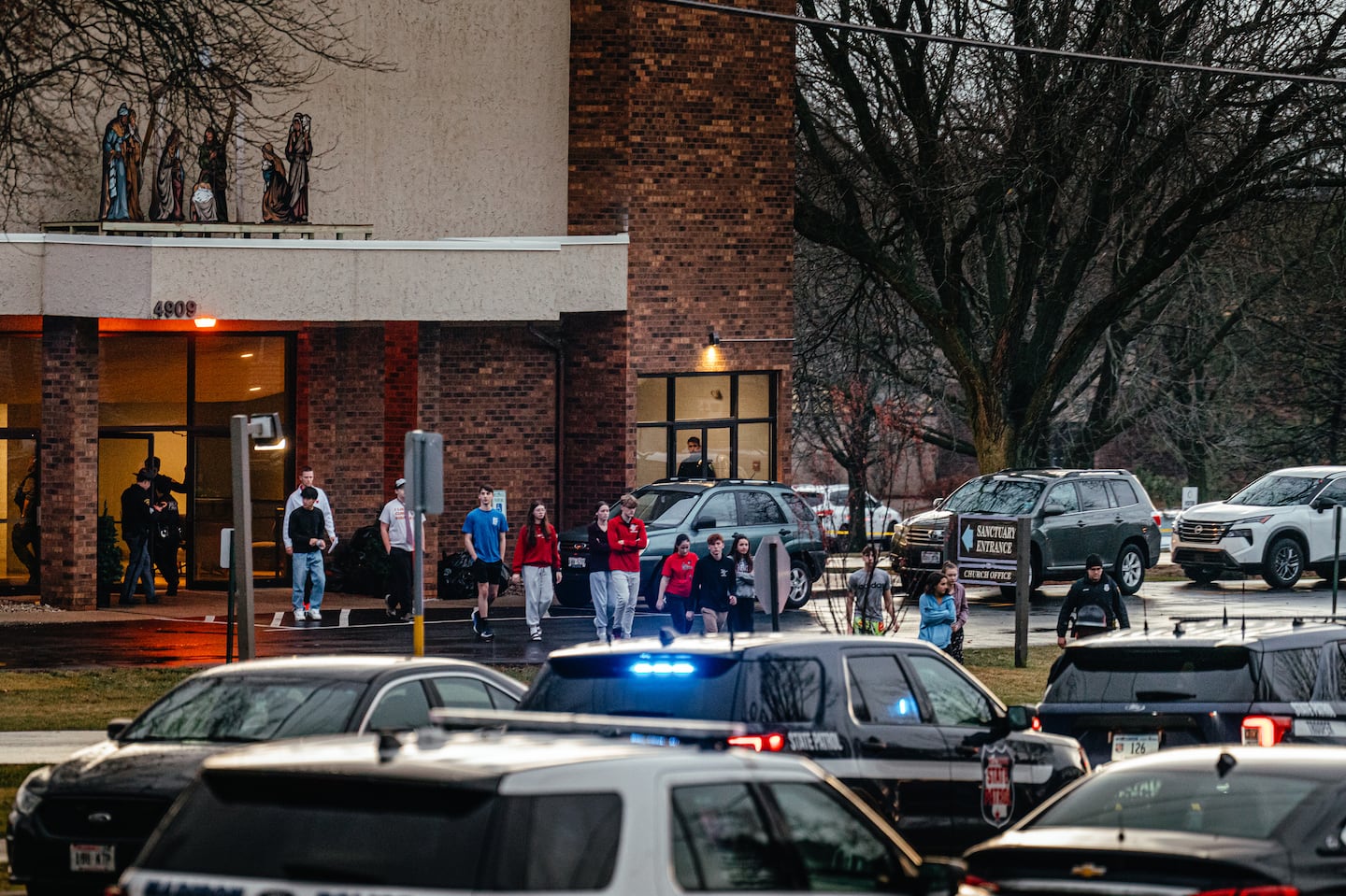 Children leave the City Church Sanctuary to board buses to reunite with their families after a shooting at the Abundant Life Christian School in Madison, Wis., on Dec. 16.