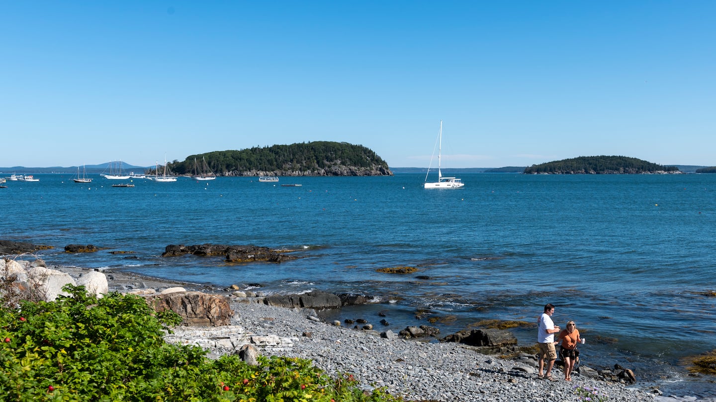 Two people walk along Bar Harbor Town Beach on a sunny Sunday morning on Sept. 17, 2023.