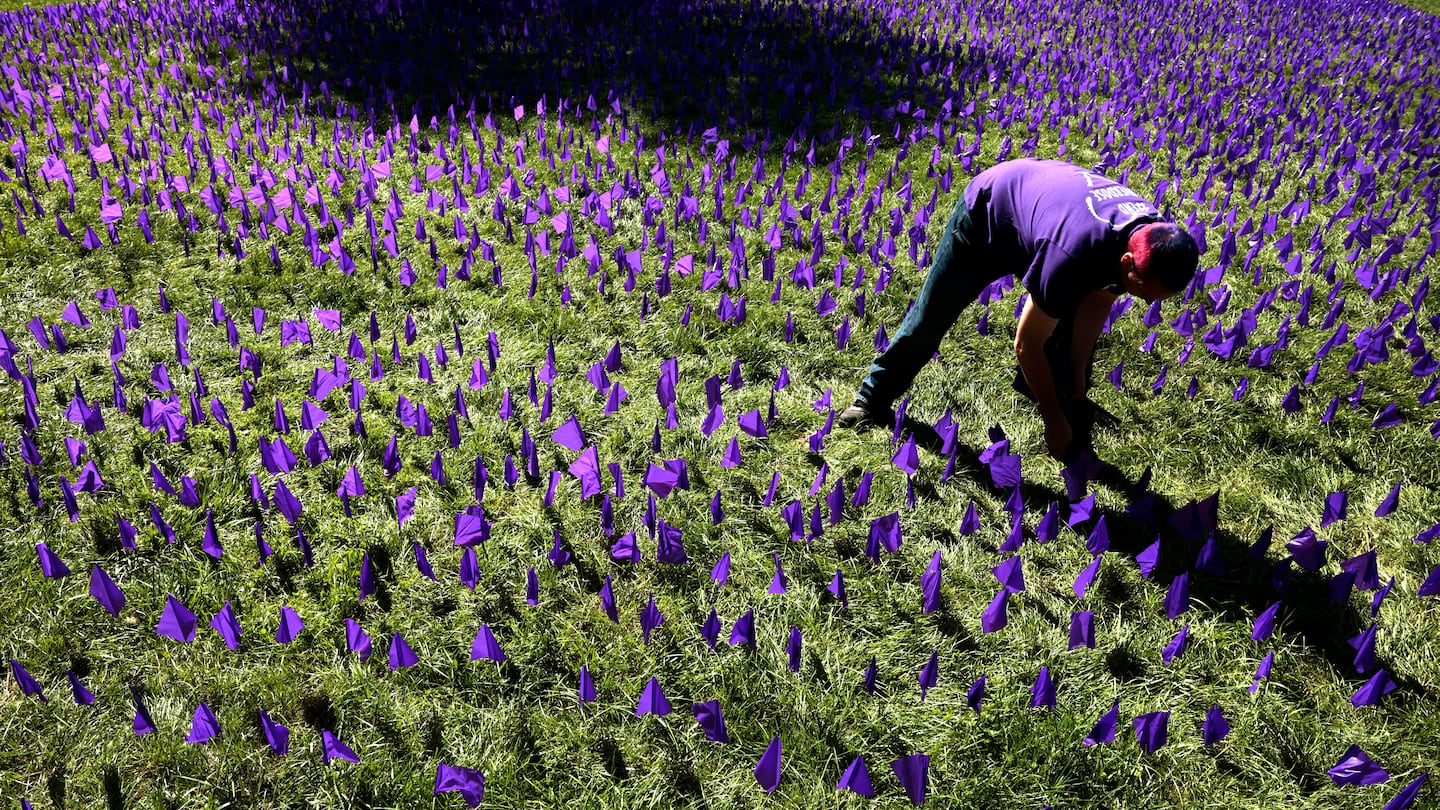 Somerville City Councilor J.T. Scott placed purple flags in the ground during the Department of Public Health’s International Overdose Awareness Day Flag Planting event on Boston Common in August 2023.