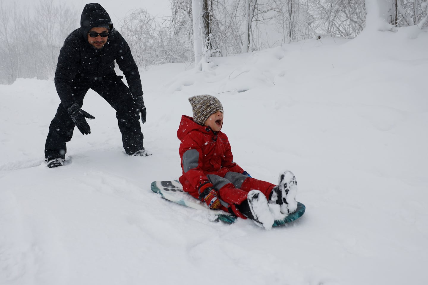 Randy Veras, left, gave his five year-old son Isaac a push as he sledded down a hill in Winnekenni Park in January. 