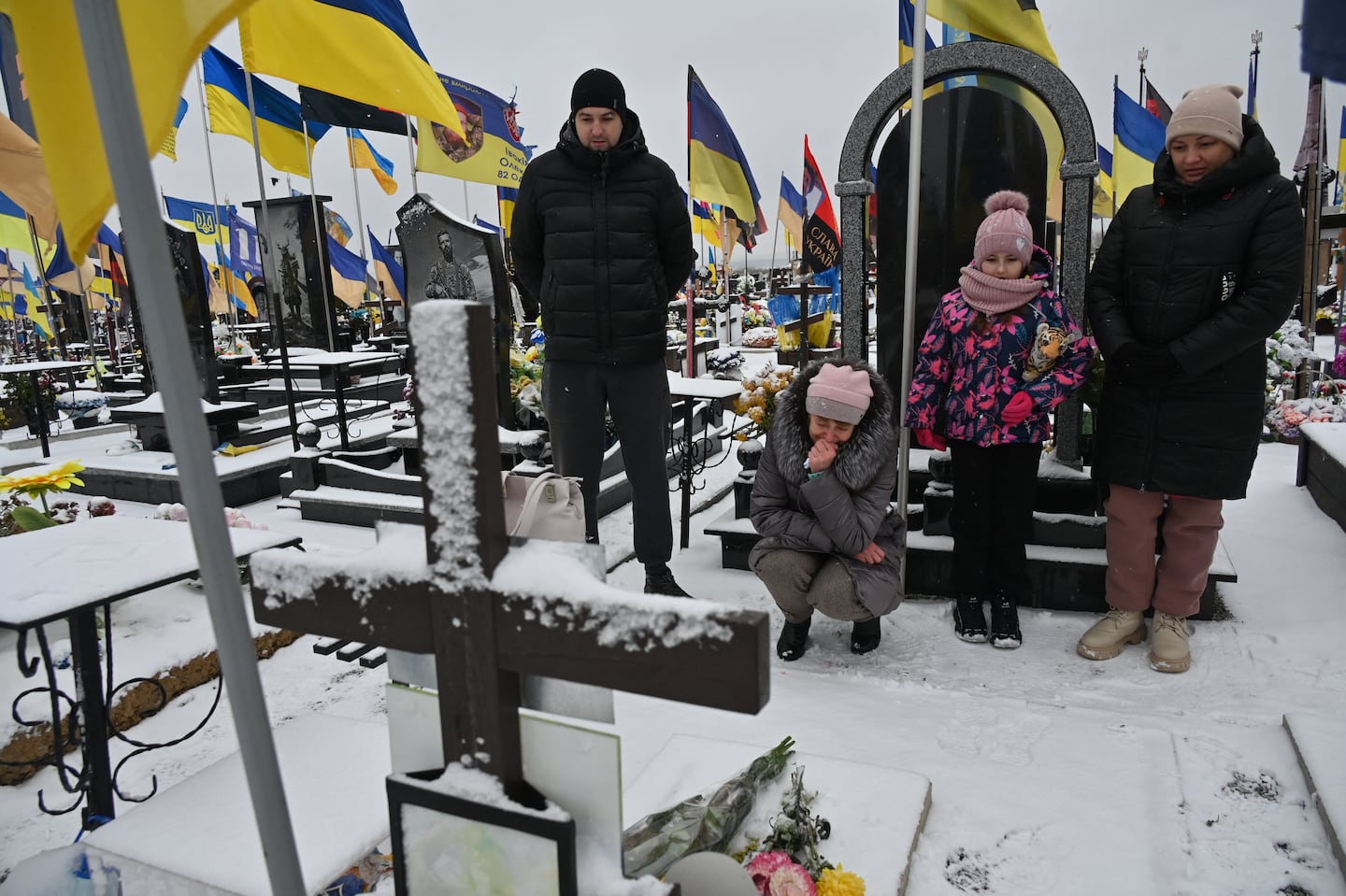 Family members mourned near the grave of a Ukrainian soldier on the Day of the Armed Forces of Ukraine at a cemetery in Kharkiv, on Dec. 6.