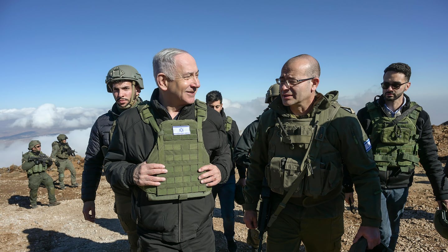 Israel's Prime Minister Benjamin Netanyahu, left, visits Israeli forces in a buffer zone inside Syria, on Dec. 17.