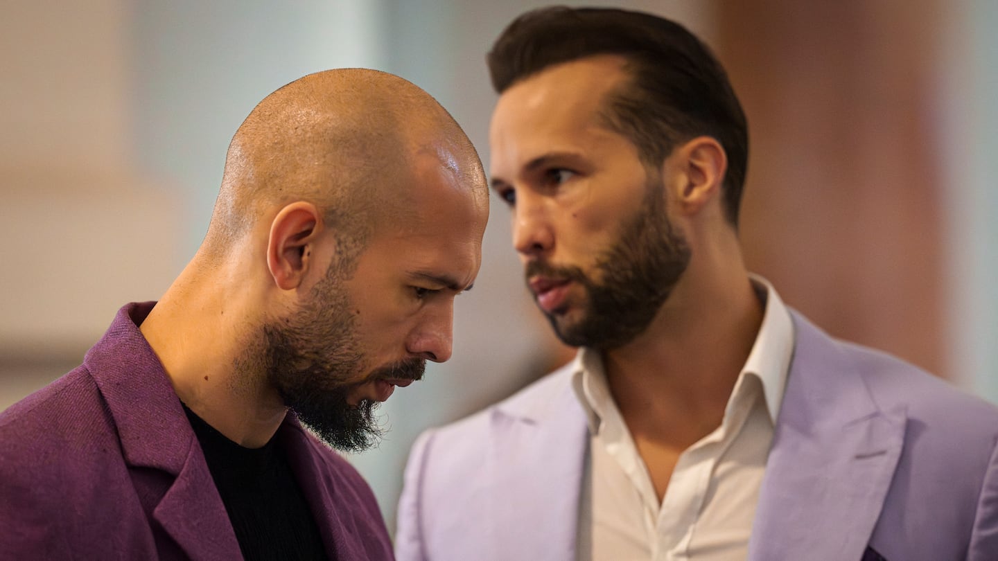 Andrew Tate, left, listens to his brother Tristan, right, at the Court of Appeals building in Bucharest, Romania, on Dec. 10.