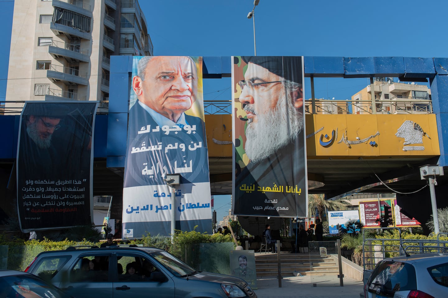 The photos on these banners in a Beirut suburb say a lot about the governance of Lebanon. On the left is the speaker of Parliament, Nabih Berri. On the right is Hassan Nasrallah, who was killed by an Israeli strike on Sept. 27. Lebanon hasn’t had a president for two years because Hezbollah keeps blocking candidates.