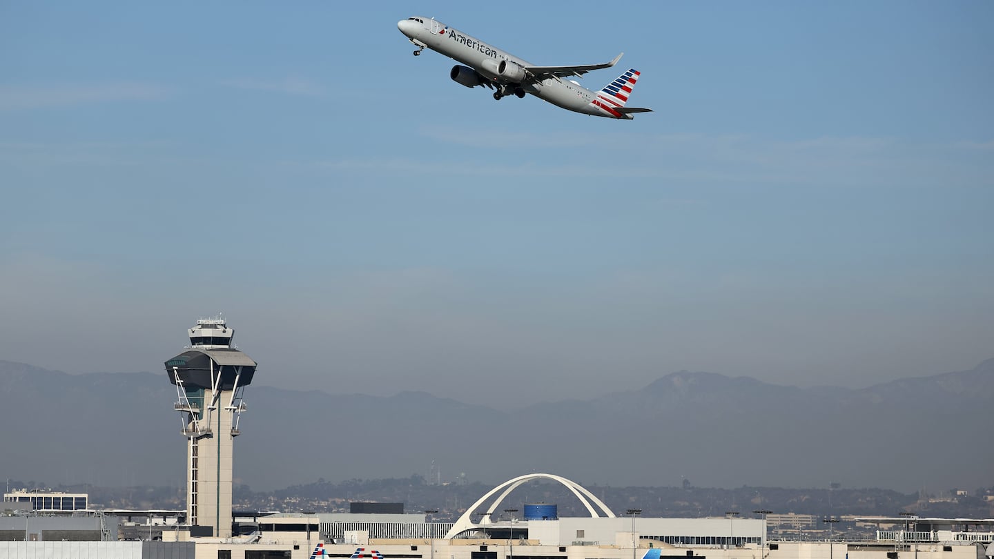 An American Airlines plane takes off as a United Airlines plane taxis at Los Angeles International Airport on December 2, 2024 in Los Angeles.