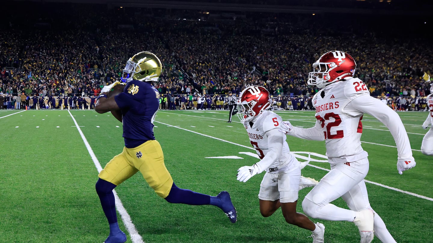 Notre Dame running back Jeremiyah Love (left) outruns a pair of Indiana defenders on his way to a 98-yard touchdown that gave the Fighting Irish the lead in the first quarter of the College Football Playoff first-round win.