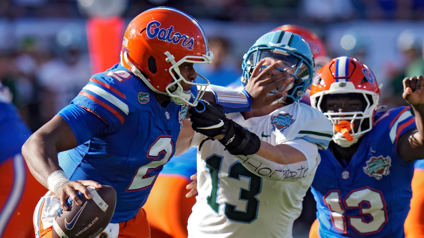 Florida quarterback DJ Lagway (left) stiff-arms Tulane linebacker Tyler Grubbs during the Gasparilla Bowl.