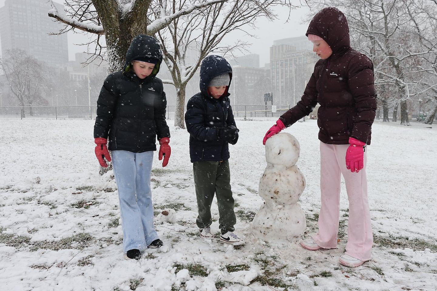 Peyton Bateup, 8, and his siblings Brooklyn, 6, and Arizona, 10, all visiting from Australia, were thrilled to have snow to play with as snow fell at Boston Common on Friday.