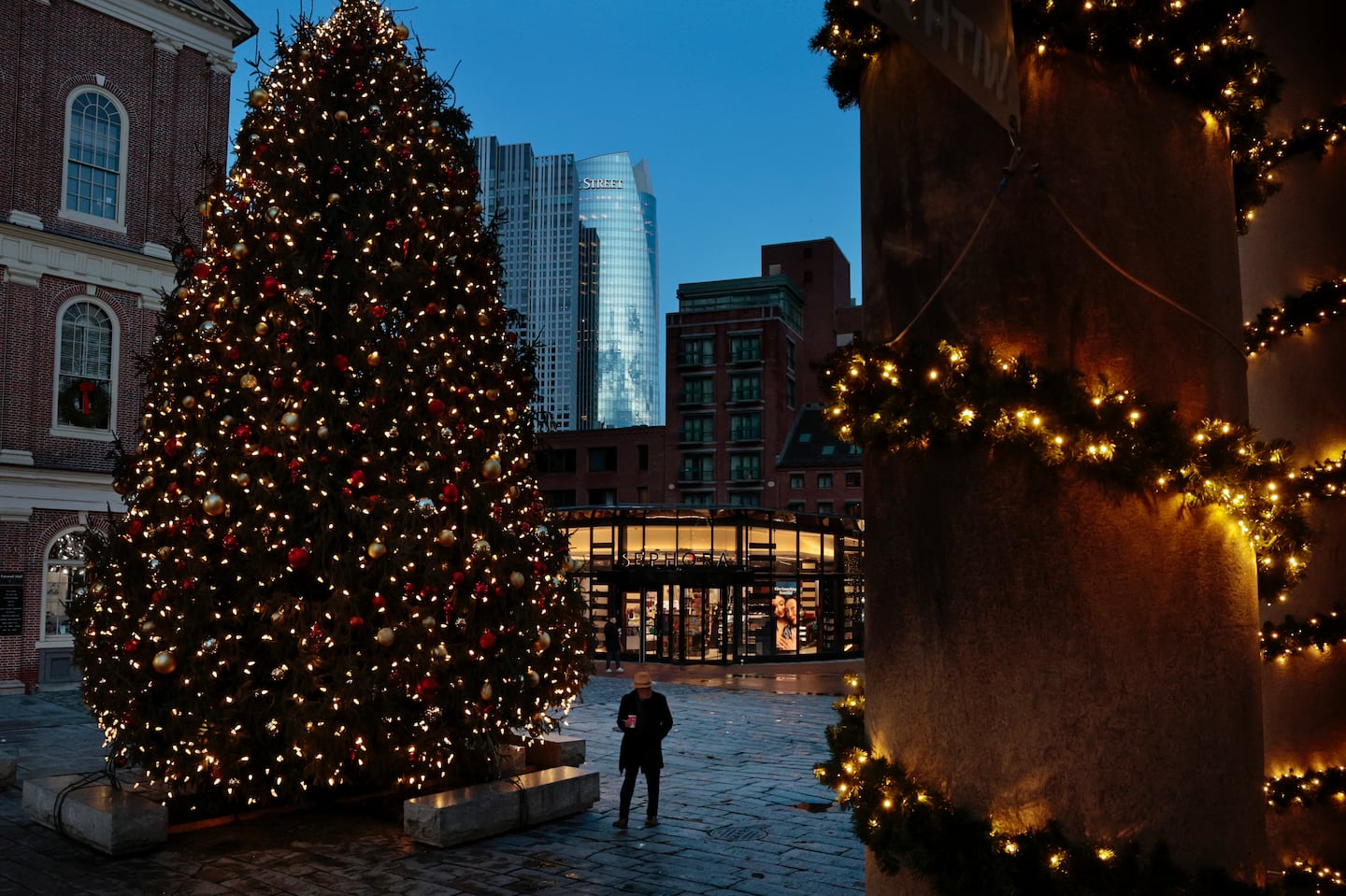 A pedestrian passes the Christmas tree at Faneuil Hall Market Place in Boston, MA on December 19, 2024.