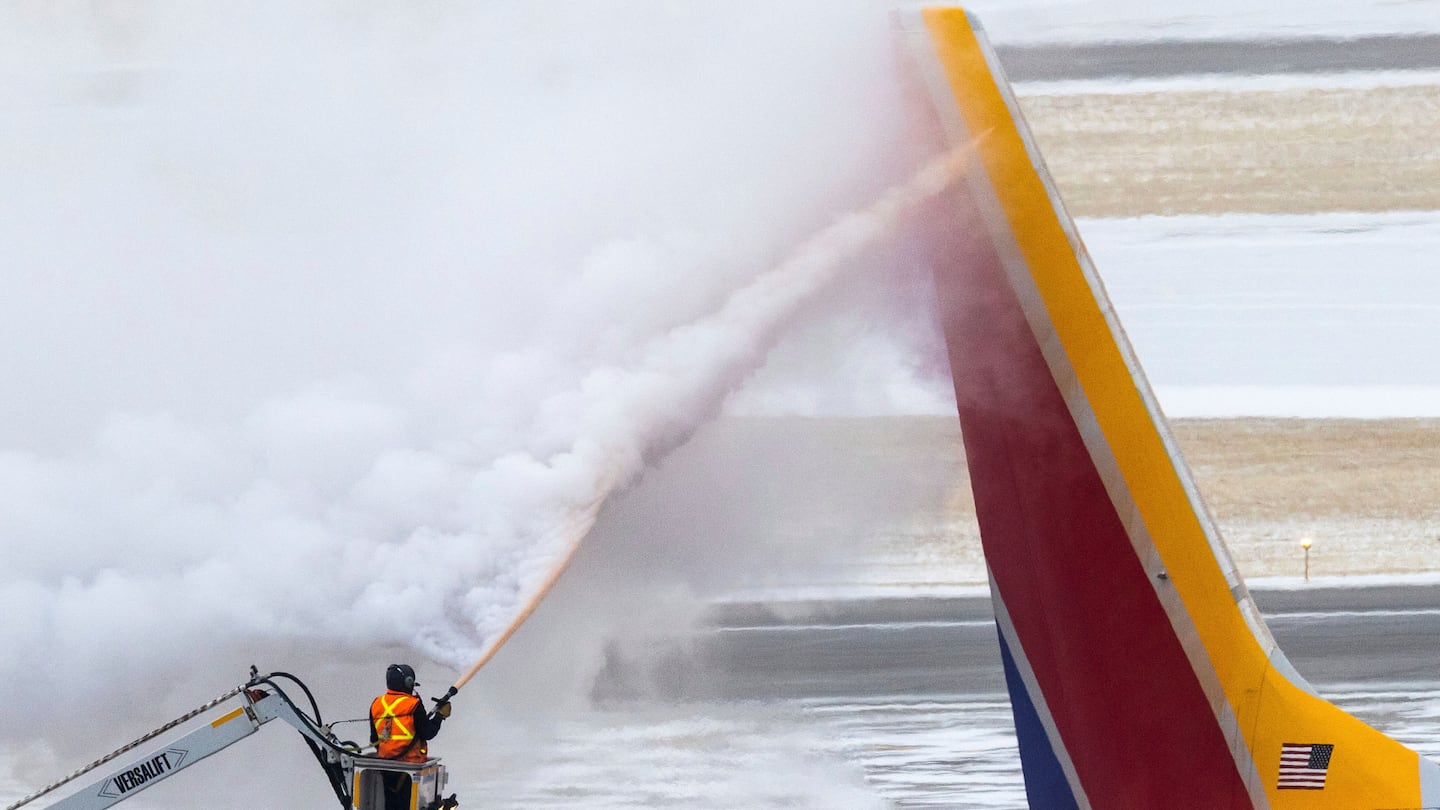 Crews deice a Southwest Airlines plane before takeoff on Dec. 21, 2022 in Omaha, Neb. Depending on where you're traveling this year, storms could disrupt your plans in the days leading up to Christmas and Hanukkah.